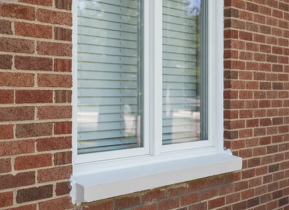 New white vinyl replacement window in a brick wall